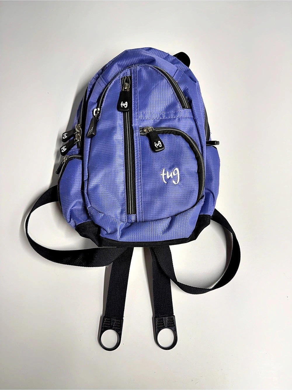 A purple Tug brand mini sling backpack